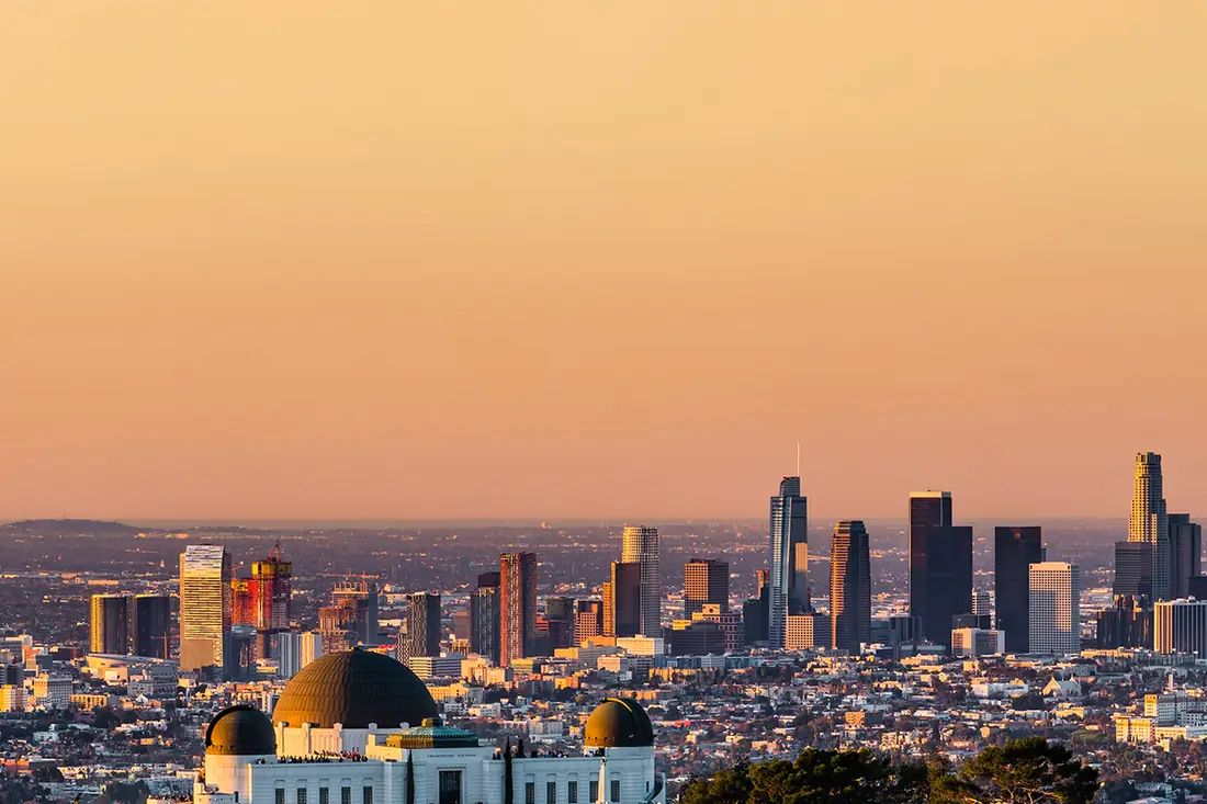 Los Angeles at sunset, seen past the domes of Griffith Observatory.